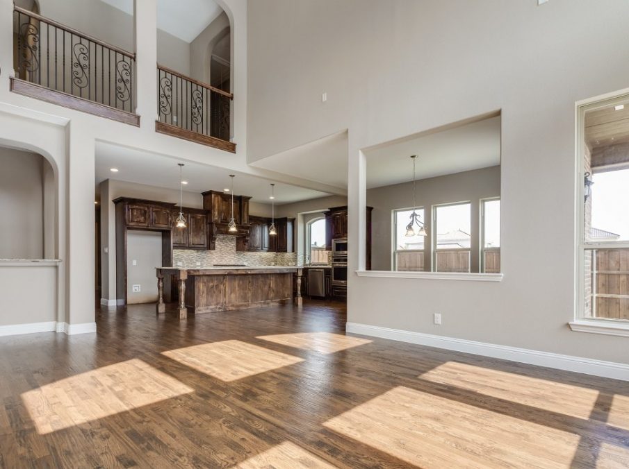 Landon Homes new home builder 432 Carrington Family Room white couch brown coffee table with kitchen in the back