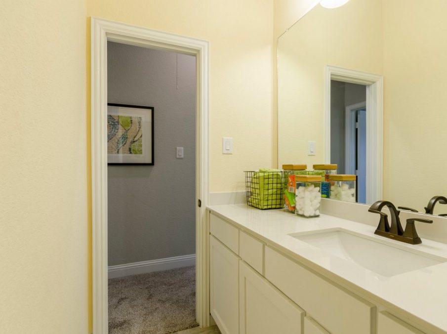 Landon Homes new home builder 432 Carrington Kids Bath with yellow walls and white painted cabinets